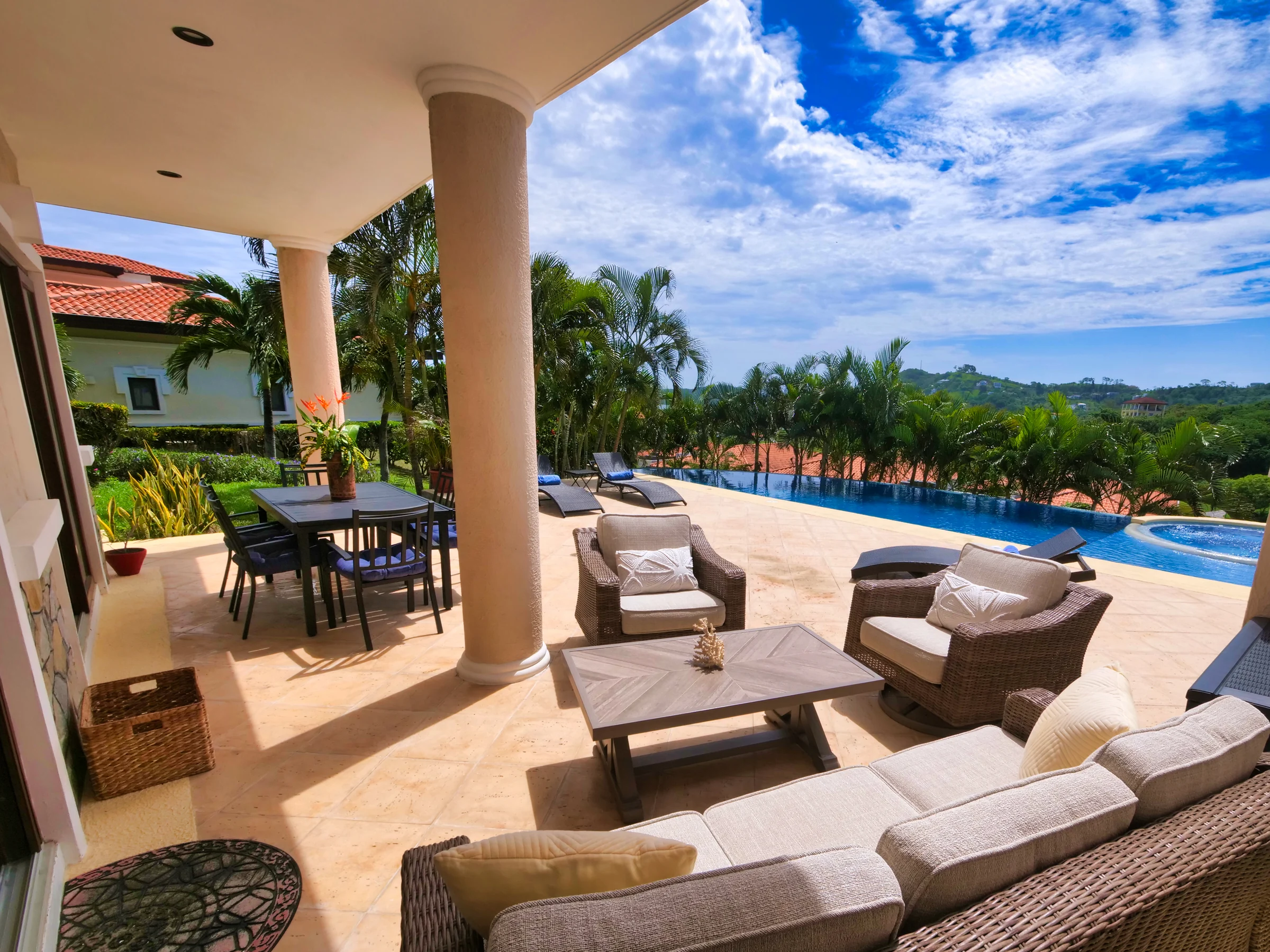 Covered patio and seating beside the villa pool