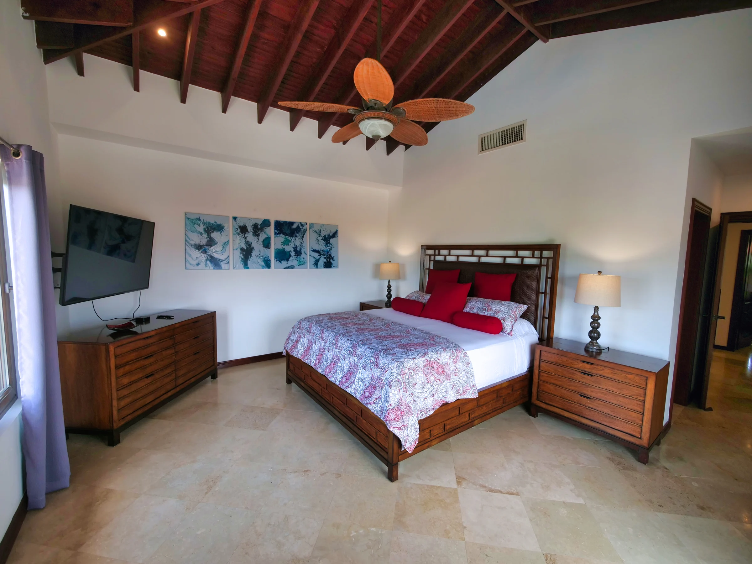 Primary king bedroom with windows and tropical views