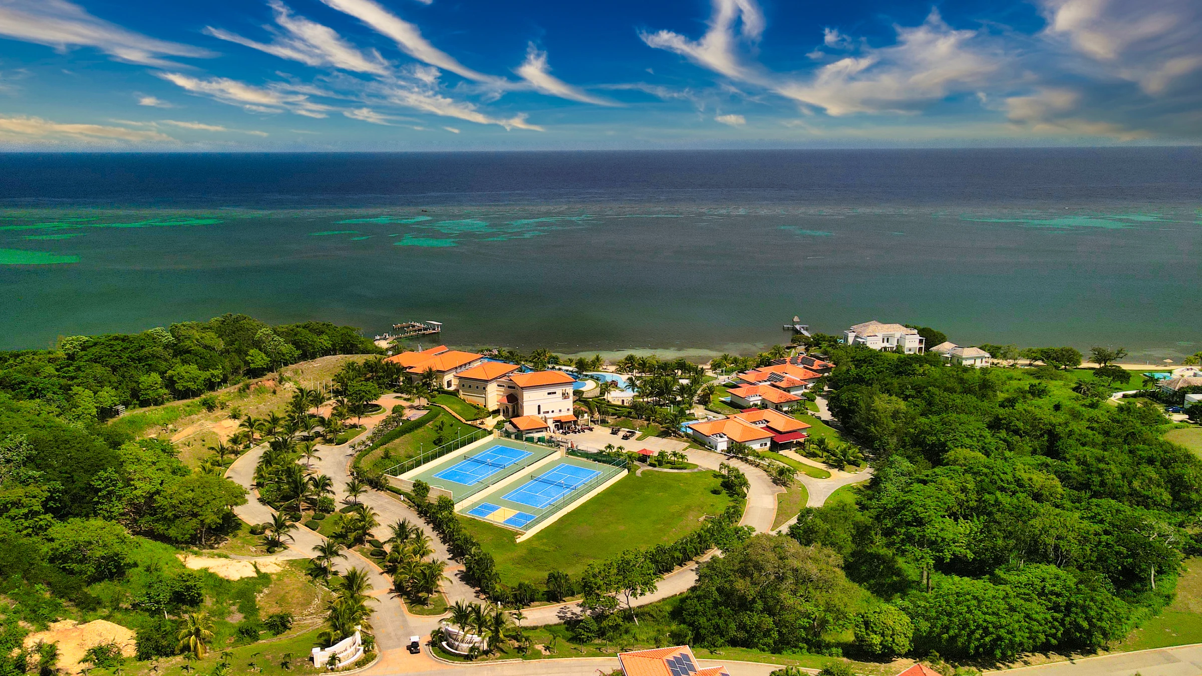 Aerial coastline and green hills around Pristine Bay, Roatán